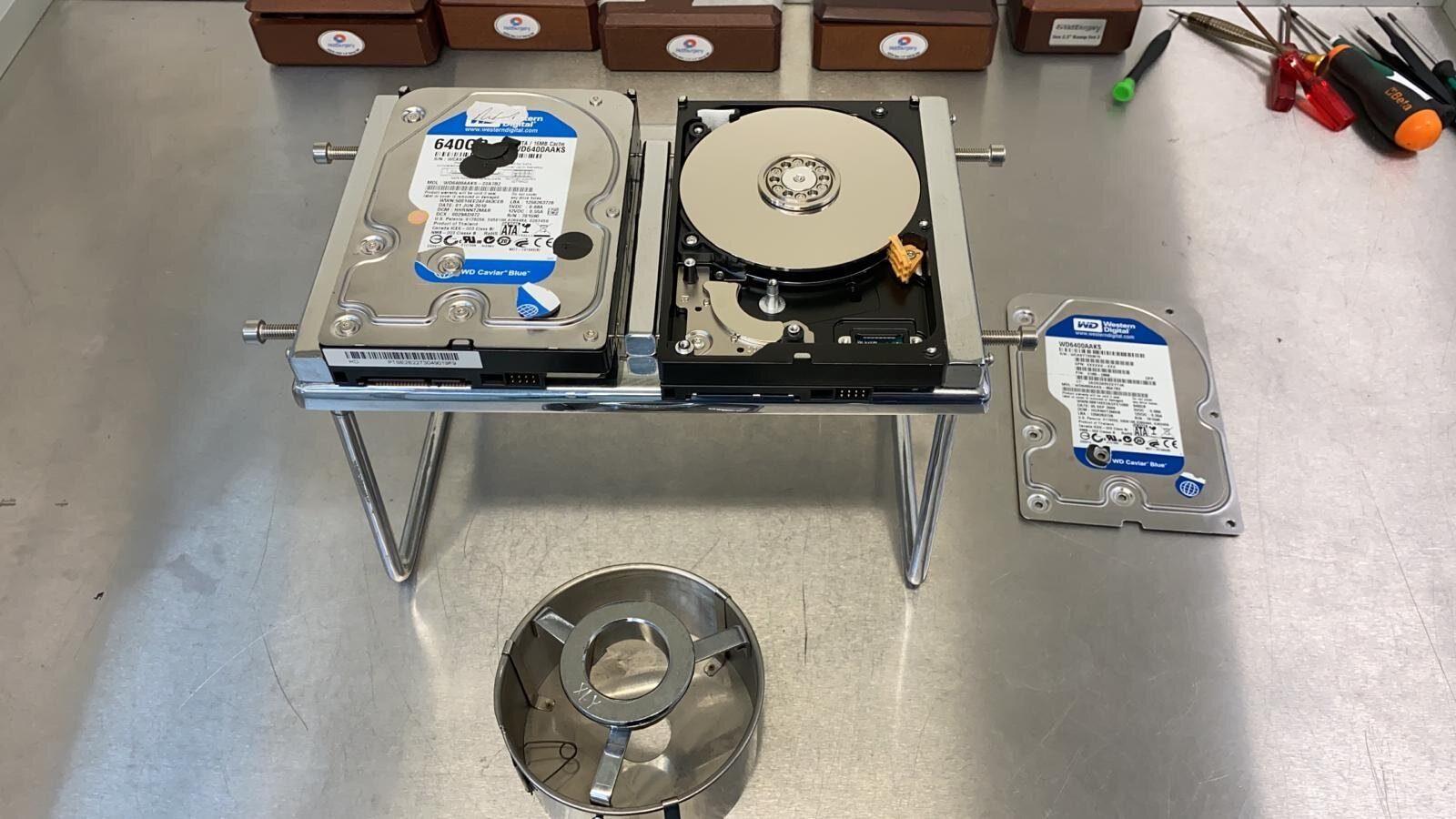 Two opened hard drives on a stand inside a clean-air cabinet
