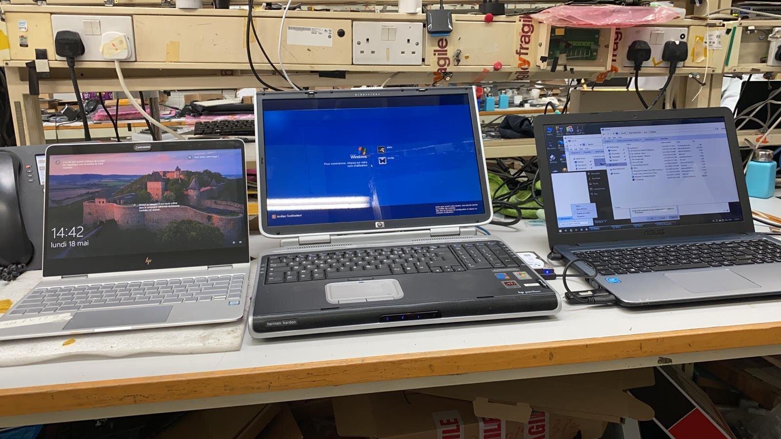 Three Windows laptops running on the workshop bench